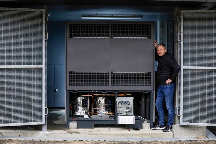 Henrik Vogensen Hvid ved siden af den ene af de to kæmpe varmepumper ved OK's nye bygning. Fotograf: Ole Hartmann Schmidt