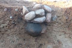 Foto 2 Urnen fra grav 14 har et lerfad som låg. Ovenpå lerfadet er der stablet en masse sten. Foto Moesgaard Museum