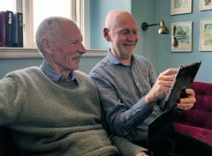 Jørgen Oldenburg (tv.), der lider af Alzheimer, og hans ægtefælde Ole Morten Nygård ser ErindringsBio på en iPad.