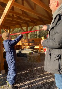 Magnus Ivarsen klipper snoren mens skoleleder Uffe Lilholm holder snoren på plads.
