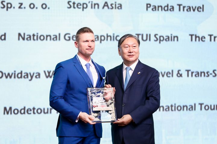 Dong CHEN (right), Party Secretary of Beijing Bureau of Culture and Tourism, gives an award to RANDALL DEER, founder and managing director of IGNITE TRAVEL of Australia