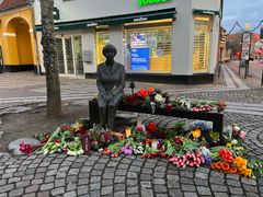 Mange har lagt blomster ved skulpturen af Lise Nørgaard på Algade i Roskilde. Stedet vil være en af de lokaliteter, der gøres stop under mindevandringen den 16. januar. Foto: ROMU