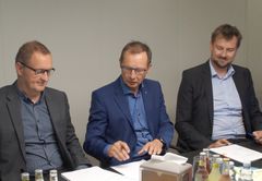 Willy Feddersen, H.P. Geil og Jakob Petersen underskriver kontrakten.