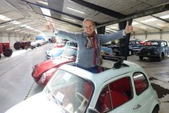 ”PR-chef Annette Kjær fra Campen Auktioner demonstrerer glad en Fiat 500 og hvordan den også kan give vind i håret”