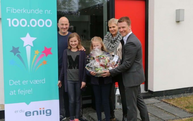 Familien Thrane (fra venstre: Ulrik, Sascha, Silke og Mirja) får overrakt en gavekurv af Eniigs fiberdirektør, Søren Lindgaard (th.)