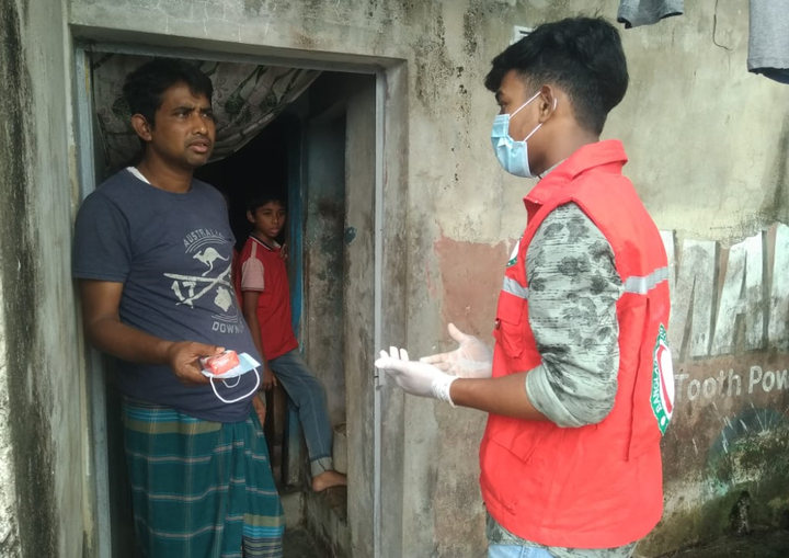 Frivillig i flygtningelejren Cox Bazar deler information og beskyttelsesudstyr ud om Covid19.