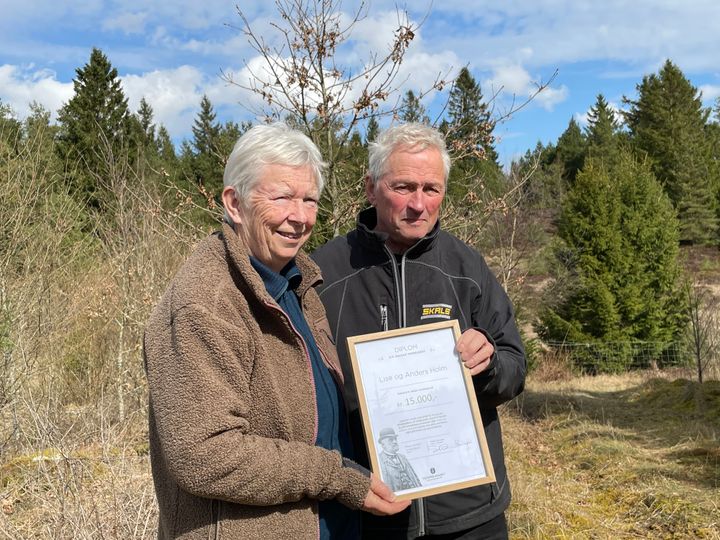 Lise og Anders Holm i den del af skoven, der blev plantet i 2010. Ægteparret står med det diplom, der følger med legatuddelingen. Legatet giver støtte til initiativer, som medvirker til beplantning, læplantning, opdyrkning og kultivering eller andet, der omfattes af Hedeselskabets formålsparagraf.