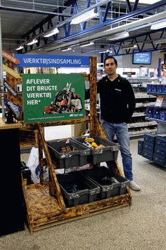 Foto af butiksmedarbejder ved podiet for værktøjsindsamlingen i Carl Ras butikken i Herlev. Fotokreditering: Carl Ras.