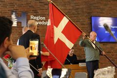 Den nye Dannebrogsfane indvies til regionrådsmødet tirsdag. Repræsentant fra Danmarks-Samfundet Erik Fage-Pedersen hjælper til med at sikre, at indvielsen foregår efter de stolte traditioner.