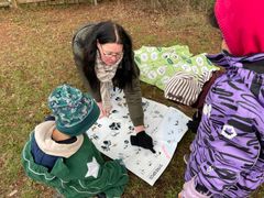 Pædagog Diana Sandberg Larsen taler med børnene om dyr, de har set spor fra på naturlegepladsen.