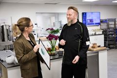 Konsulent Ingrid Elmedal fra Miljømærkning Danmark overrækker beviset for en svanemærket kantine til køkkenchef Heine Skriver