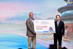 Yu SONG (right), Director General of Beijing Bureau of Culture and Tourism, gives an award to Paul COHEN, managing director of International Experiences of the US