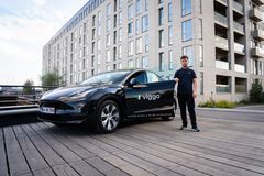 Viggo har netop fået den nye Tesla Model Y til flåden. Det er den første Model Y-taxi i Skandinavien. Billedet viser bilen og chaufføren, der skal køre den. Foto: Viggo