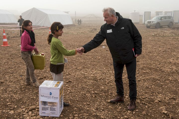 En lille yezidi-pige siger tak til Mission Østs generalsekretær Kim Hartzner for en varmeovn, der kan hjælpe hendes familie med at holde varmen i deres telt gennem vinteren. Foto: Peter Eilertsen.