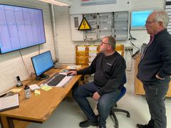 Storskærmen med den digitale produktionsplan er hovednerven i Syd Elektros digitaliseringsløft. Systemet er bygget på Excel, og de to ejerledere bruger og vedligeholder det med de Excel-kompetencer, som de har fået fra Compress-konsulent Niels Otten (th.). Foto: Erhvervsstyrelsen