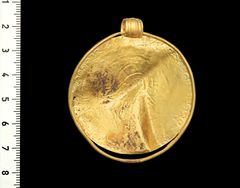 The back side of the gold bracteate with the Odin inscription. Photo: Arnold Mikkelsen, The National Museum of Denmark.
