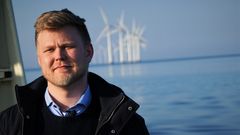 Frederik Roland Sandby foran kystnære vindmøller i København. Fotograf: Ariel Storm / Klimabevægelsen i Danmark. Fri afbenyttelse.