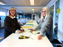 Et af de projekter, der støttes, er vimpelprojektet, hvor frivillige har strikket vimpler i tourens farver. Her er det Lis Birte Thrane og Lis Klynder, der er ved at sætte dem på snor. Vimplerne skal blandt andet hænges op på det smalle stykke af Jomfrustien.
