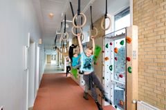 På Engstrandskolen i Hvidovre har Virklund Sport lavet en kedelig gang om til en bevægelsesstation ved hjælp af en klatrevæg og romerske ringe. Foto: PR.