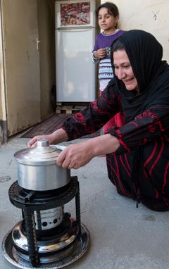 Kvinde glæder sig nu over at kunne lave med på det kogeapparat, hendes familie har modtaget fra Mission Øst.