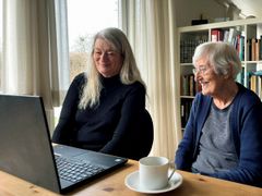 Anne O'Neil og hendes mor Sonja Elisabeth Hansen på 97 år ser ErindringsBio på computeren hjemme i stuen.