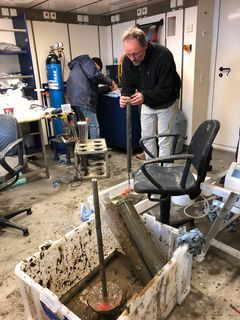 Ombord på forskningsskibet skærer Ronnie N. Glud sediment op, hvorefter det bliver frosset eller kølet ned til videre analyse. Foto: Anni Glud/SDU.