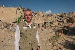 En rystet Kim Hartzner foran den sønderskudte og udbombede by Sinjar. Foto: Peter Eilersen.