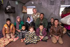 Kim Hartzner sammen med Hadji og hans familie, som netop har modtaget varmeovn og brændstof fra Mission Øst. Hadji var fange hos IS i 11 dage, inden han formåede at flygte. Foto: Peter Eilertsen.