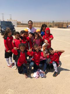 Khalida Popal omgivet af Syriske flygningepiger inden fodboldtræning