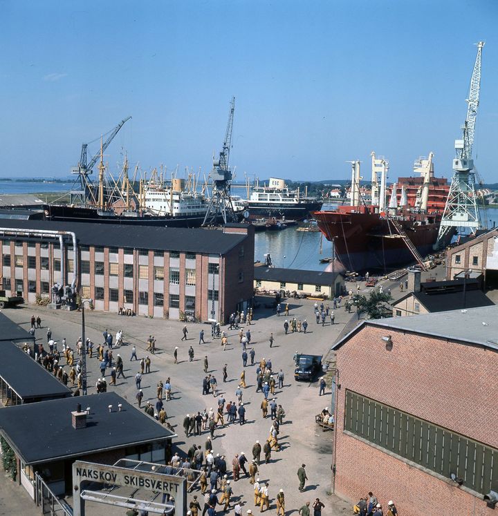 Frokostpausen er slut på Nakskov Skibsværft, og værftsarbejderne myldrer ud på pladsen d. 11. august 1970. Foto: Thomas Hald/Nakskov lokalhistoriske Arkiv.
