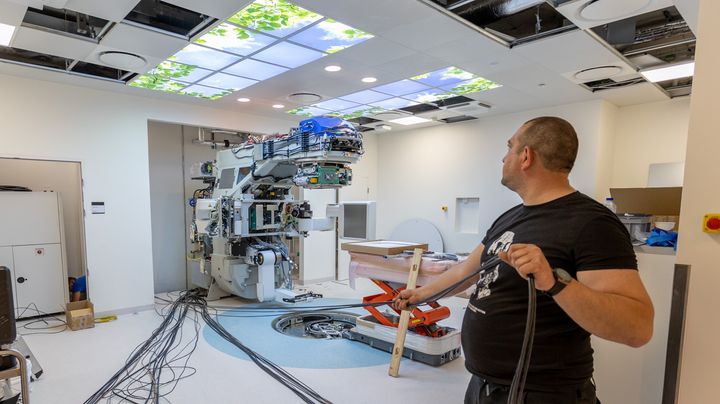 Tekniker installerer ny accelerator i stråleklinikkens kommende nye lokaler i Gødstrup. Foto: Søren Braad Andersen.