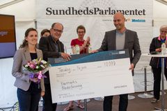 Kasper Tingkær, generalsekretær i Depressionsforeningen, overrækker SundhedsParlamentets pris for ”Bedste initiativ” til Terkel Andersen og Naja Skouw-Rasmussen fra Danmarks Bløderforeningen.