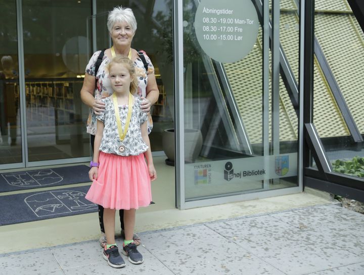 Vinder af Ferieindianer på Vibeholmskolens område, Mina Møller-Karlsen med sin farmor, Lillian Karlsen. De står foran indgangen til Ishøj Bibliotek fra Ishøj Byhave.