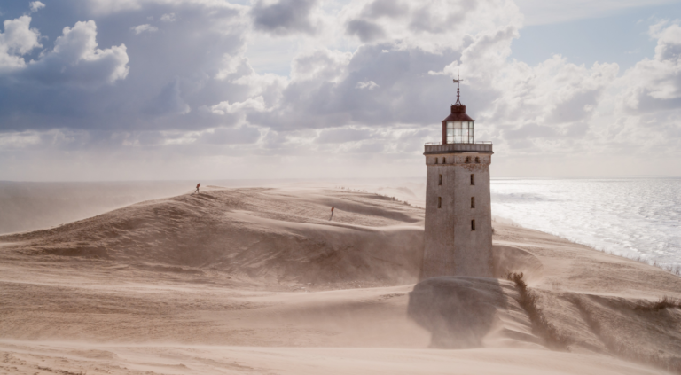 Fyrtårn ved strand - stock