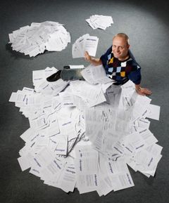 Så få var utilfredse. Direktør Søren Riis holder de 18 negative besvarelser i hånden og har sat sig på bunken med de 7.112 storsmilende smileys. I baggrunden til venstre de 1.750, der gav Riis Rejser en behersket positiv smiley og bagest til højre de 92 n