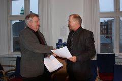 Dansk El-Forbunds formand, Jørgen Juul Rasmussen, giver hånd på Elekrtikeroverenskomsten.