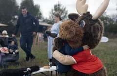 Sparekassen Kronjyllands maskot, som er en plysset kronhjort, giver et kram til et af de fremmødte børn.
