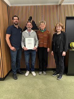 Repræsentanter fra Påskeudstillingen Det Røde Pakhus sammen med Christian Munkholm(tv), bestyrelsesmedlem i Fonden for Andelskasserne i område Nord og Lene Nielsen(th), centerdirektør i Andelskassen i Hobro