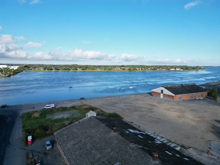 Luftfoto af et havneområde med en bygning ved vandet.