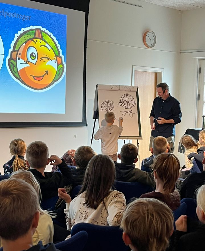 Jan Kjær tegner med en skoleelev