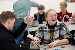 Elever, der deltager i Science Day og sidder og arbejder med gummislanger og elektronisk udstyr