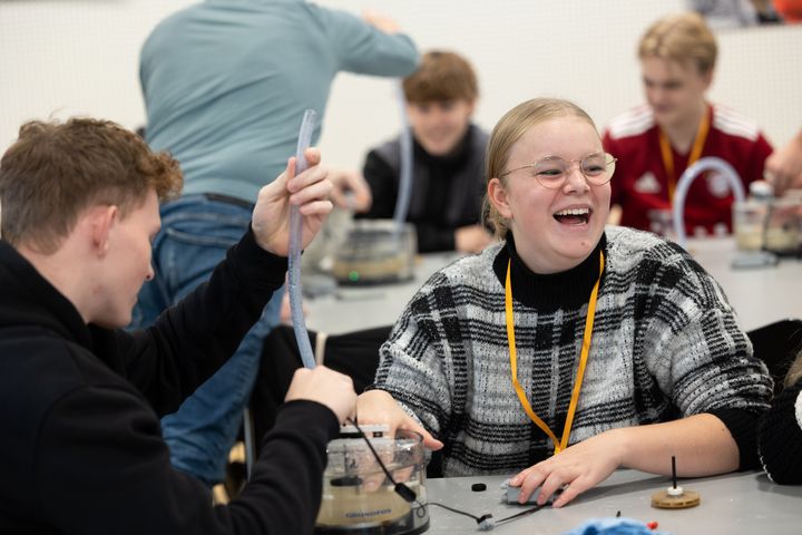 Elever, der deltager i Science Day og sidder og arbejder med gummislanger og elektronisk udstyr