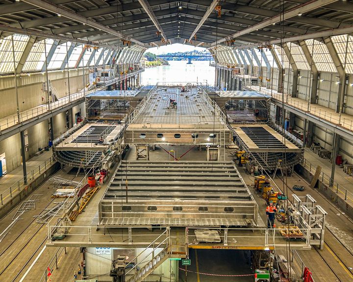 I disse enorme haller i Hobart begynder arbejdet med Molslinjens tre elektriske hurtigfærger at tage form.