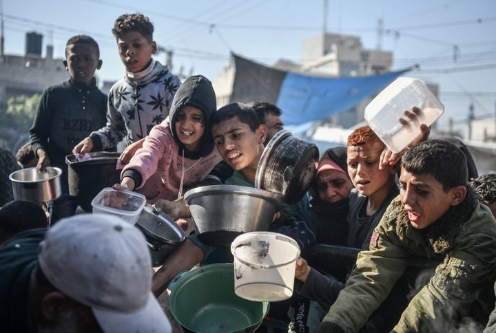 Børn i kø for at modtage en lille mængde mad i byen Rafah i det sydlige Gaza.