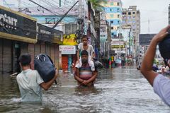 Bangladesh Feni Flood August 2024 A father carrying his son through the flood water, in Feni.  Catastrophic floods in southeastern Bangladesh, particularly in Noakhali, Feni, and Khagrachari, are wreaking havoc, in August 2024.  Over 5M people across many districts, including 2M children, are grappling with the aftermath of these ruinous floods.