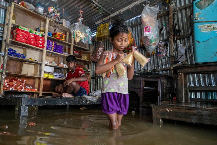 On June 20, 2024, eight-year-old Ripa wades through the floodwater to stock up on food for her family from a half submerged local grocery store in Shimultala village, Companiganj, Sylhet.  Over 2,000,000 people, including over 772,000 children, are affected by the devastating floods in north-eastern Bangladesh. Children face heightened risks of drowning, malnutrition, waterborne diseases, and trauma from displacement. UNICEF is working with the Government of Bangladesh and local stakeholders to distribute safe water and emergency supplies to the affected communities.