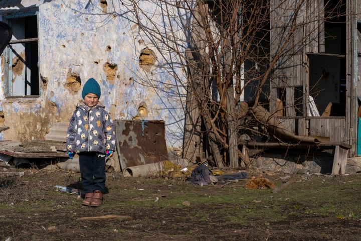 Roma på 4 år foran familiens ødelagte hjem i landsbyen Kobzartsi i Mykolaiv-regionen.