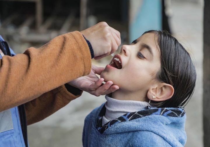 Pige får poliovaccination på en skole i Gaza city.