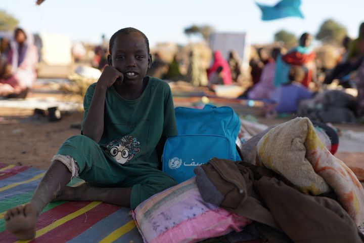 11-årige Ibrahim sidder i en lejr for internt fordrevne i Tawila, hvor hans familie er flygtet hen efter den eskalerede vold i Al Fasher.  Han bevæger sig besværet. Han halter, og en hvid bandage er viklet om hans højre knæ efter en skade forårsaget af en granat, der dræbte hans bror på stedet og efterlod ham selv med et brækket ben og granatsplinter i det andet, mens de flygtede. Billedet er taget den 24. november 2025.