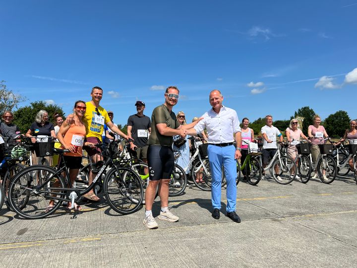 Landechef Christof Bischoff (tv) og Kenneth Øhrberg Krag foran nogle af cyklisterne fra AstraZeneca.